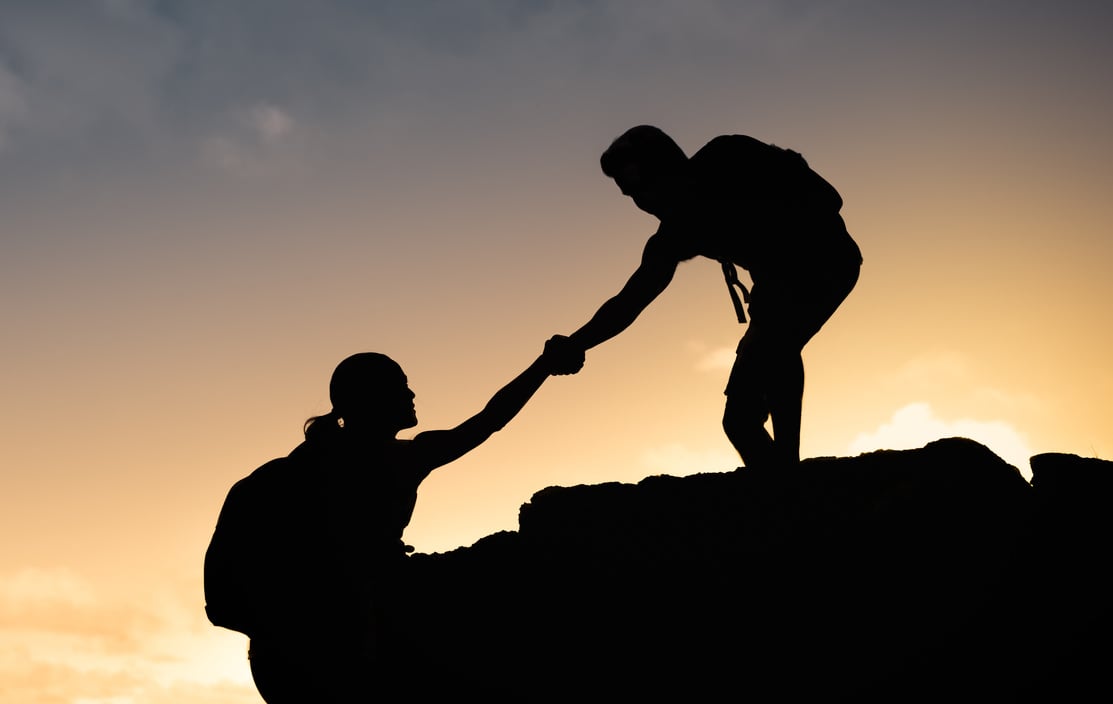 Man helping his friend during hike. Helping hikers.